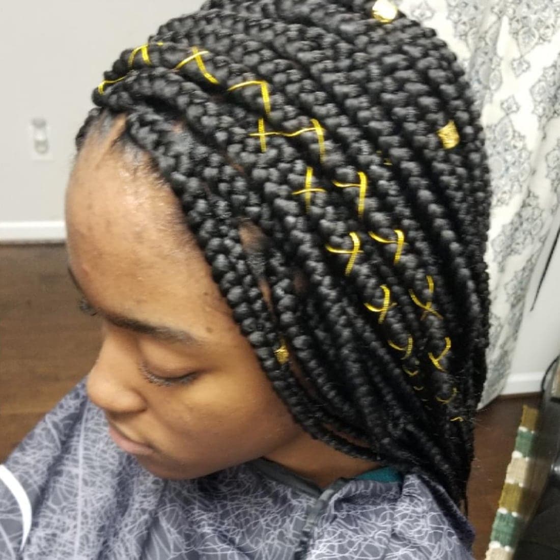 Box braids accented with gold thread